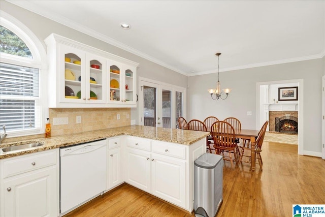 kitchen with pendant lighting, sink, dishwasher, white cabinetry, and kitchen peninsula