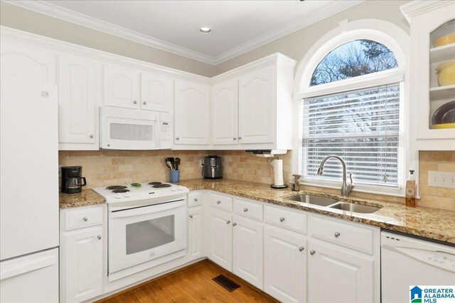 kitchen with sink, white cabinetry, light stone counters, white appliances, and backsplash