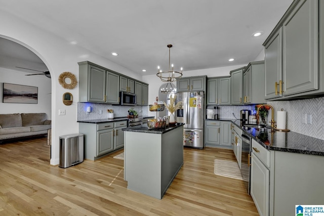 kitchen with sink, gray cabinetry, decorative light fixtures, a center island, and appliances with stainless steel finishes