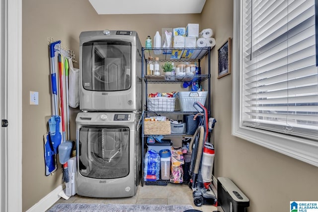 clothes washing area featuring stacked washer / dryer and light tile patterned flooring