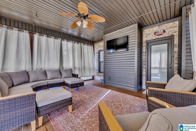 living room featuring ceiling fan, brick wall, a wealth of natural light, and wood ceiling