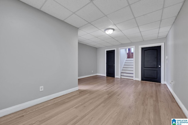 unfurnished room featuring light wood-type flooring and a drop ceiling