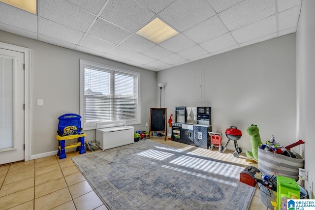 playroom with light tile patterned flooring and a paneled ceiling