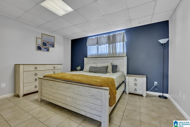 tiled bedroom featuring a drop ceiling