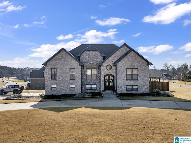 french provincial home with french doors and a front lawn