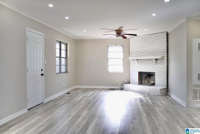 unfurnished living room with crown molding, plenty of natural light, and a fireplace