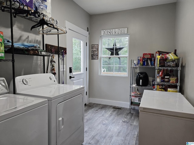 laundry room featuring laundry area, light wood finished floors, washer and clothes dryer, and baseboards