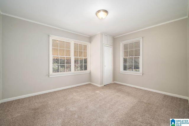 empty room with ornamental molding and light colored carpet