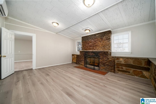 living room featuring crown molding, an AC wall unit, light hardwood / wood-style floors, and a brick fireplace