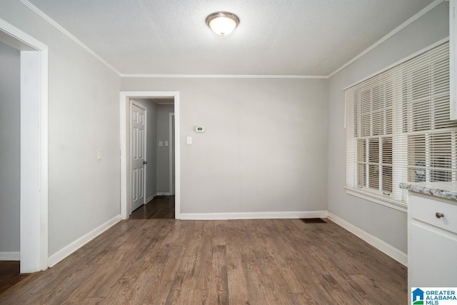 empty room featuring dark wood-type flooring and crown molding