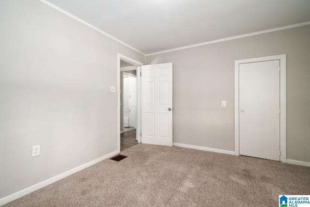 unfurnished bedroom featuring crown molding and carpet flooring