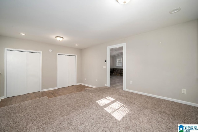 unfurnished bedroom featuring multiple closets and carpet