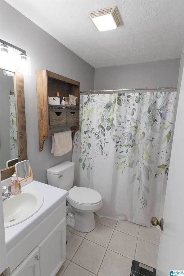 bathroom with toilet, a textured ceiling, vanity, a shower with shower curtain, and tile patterned flooring