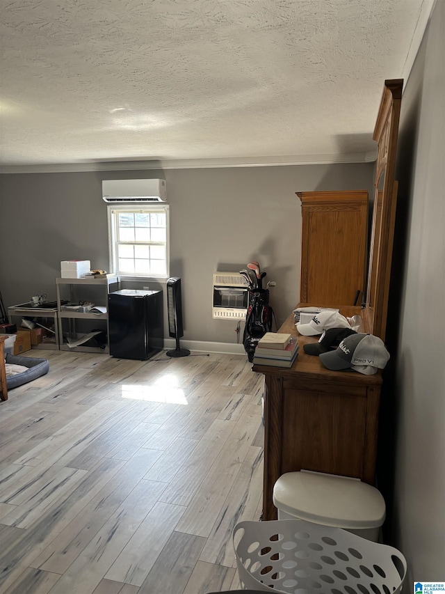 interior space with a wall mounted AC, heating unit, wood-type flooring, ornamental molding, and a textured ceiling