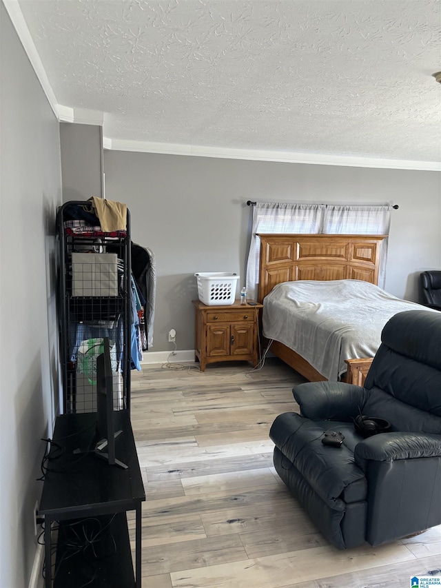 bedroom featuring crown molding, a textured ceiling, and light wood-type flooring