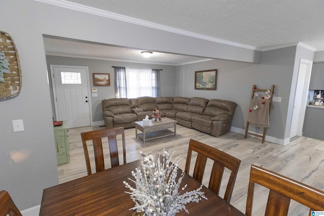 dining space with hardwood / wood-style floors, ornamental molding, and a textured ceiling