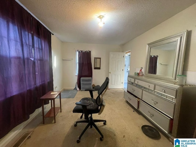 carpeted office featuring a textured ceiling