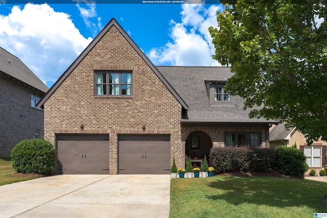 tudor-style house with a garage and a front yard