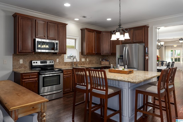 kitchen featuring light stone counters, crown molding, dark hardwood / wood-style flooring, and appliances with stainless steel finishes