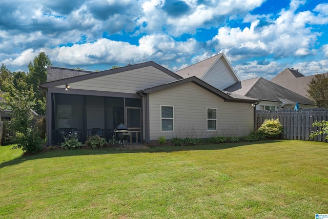 back of house featuring a yard and a sunroom