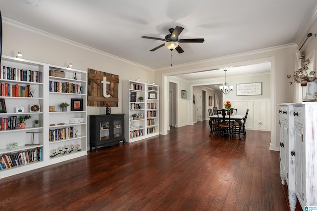 interior space with built in shelves, ornamental molding, dark hardwood / wood-style flooring, and ceiling fan with notable chandelier