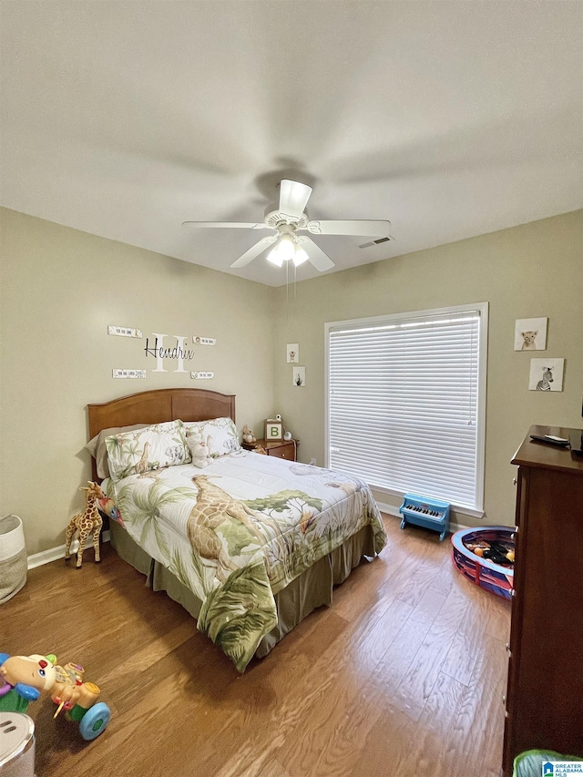 bedroom with light hardwood / wood-style flooring and ceiling fan