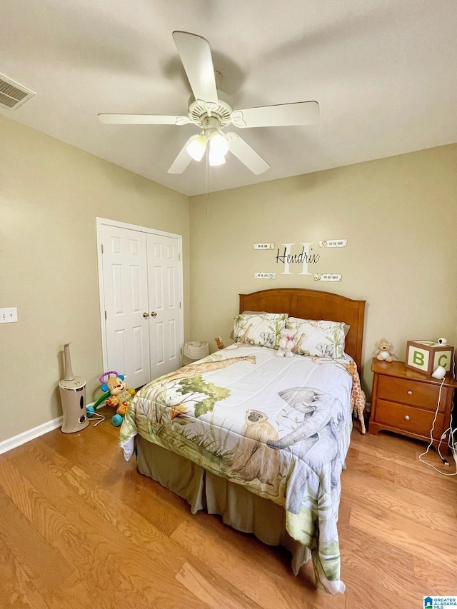 bedroom with light hardwood / wood-style floors, ceiling fan, and a closet