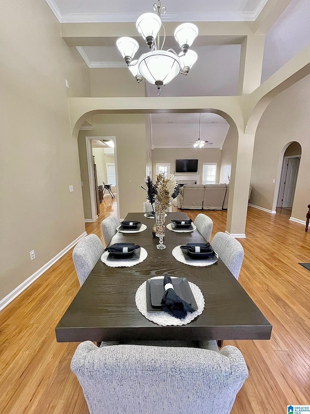 dining room with crown molding, ceiling fan with notable chandelier, and light hardwood / wood-style floors