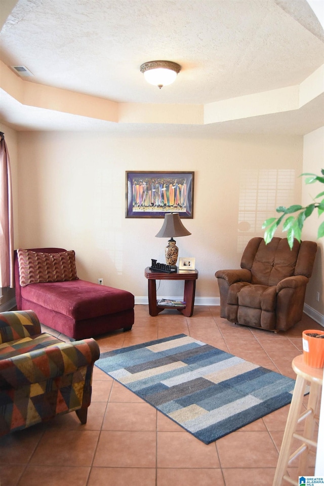 tiled living room featuring a raised ceiling and a textured ceiling