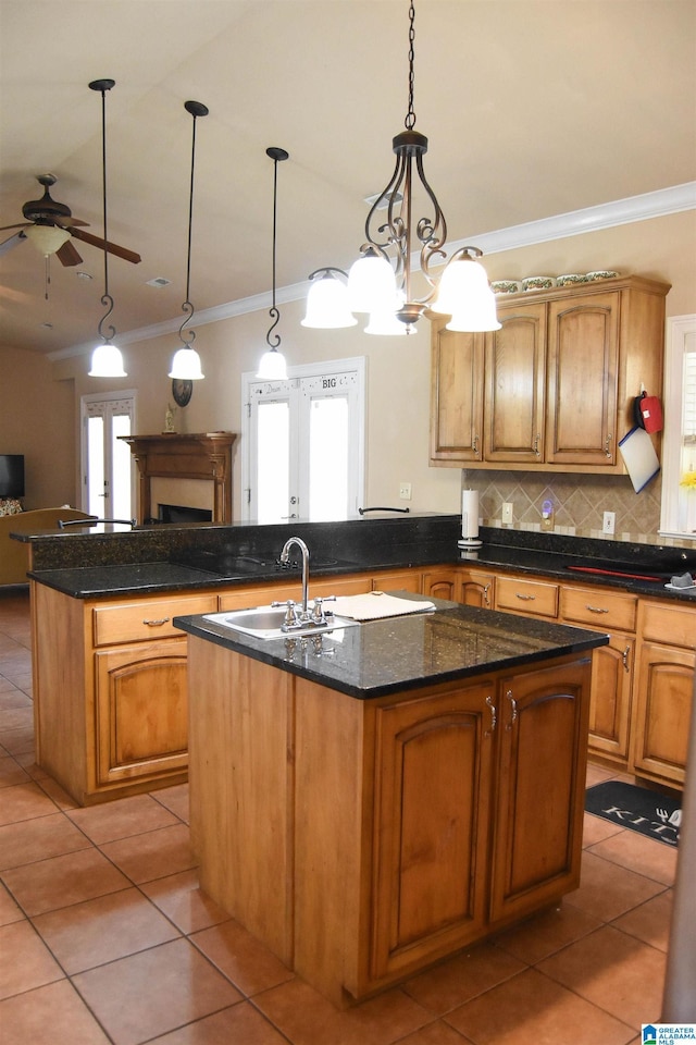 kitchen with a kitchen island with sink, sink, and pendant lighting