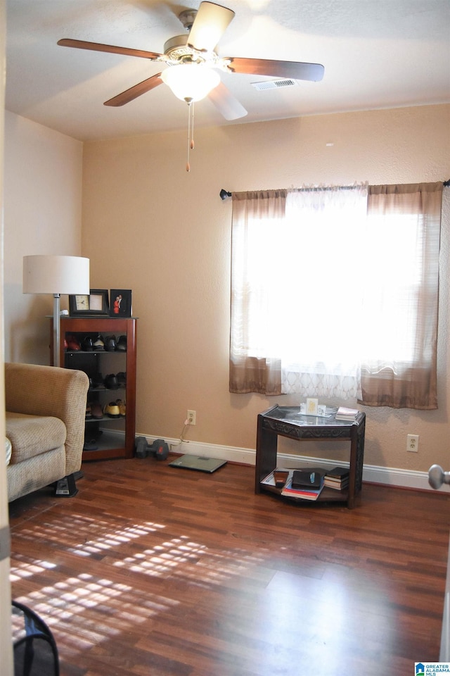 sitting room with ceiling fan and dark hardwood / wood-style floors