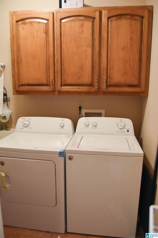 laundry room with washing machine and dryer and cabinets