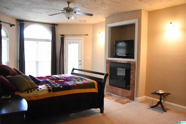 bedroom featuring ceiling fan, light colored carpet, and a textured ceiling