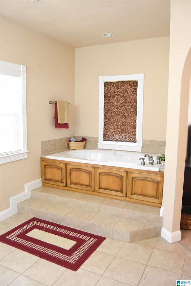 bathroom with tile patterned flooring and a bath