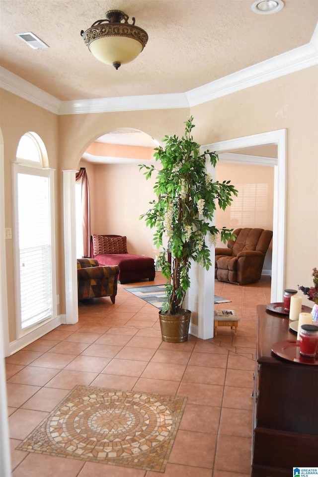 corridor with a healthy amount of sunlight, tile patterned flooring, and a textured ceiling