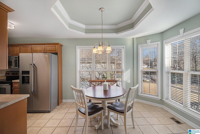 dining area featuring an inviting chandelier, crown molding, a raised ceiling, and light tile patterned floors