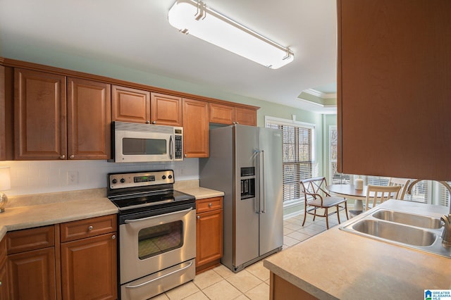 kitchen with appliances with stainless steel finishes, sink, backsplash, light tile patterned floors, and track lighting