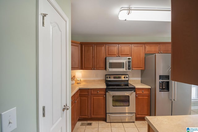 kitchen with light tile patterned flooring and stainless steel appliances