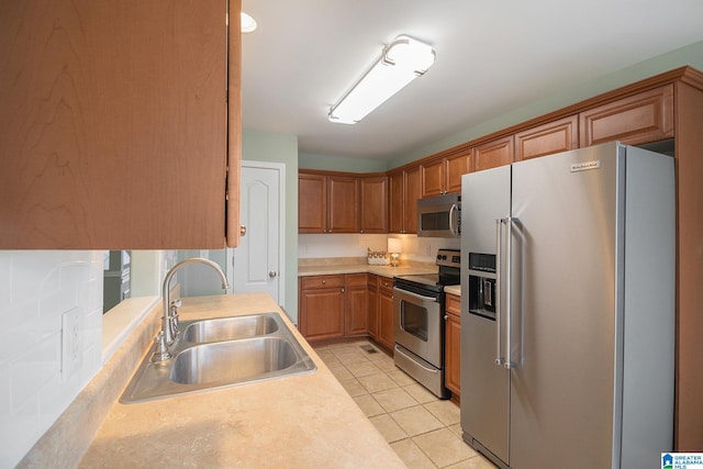 kitchen featuring stainless steel appliances, light tile patterned flooring, and sink