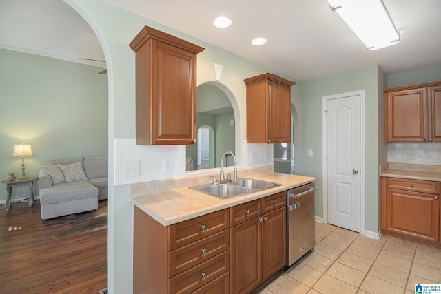 kitchen with dishwasher, sink, light tile patterned floors, and decorative backsplash