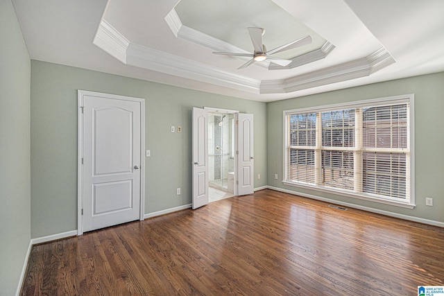 spare room featuring dark hardwood / wood-style flooring, crown molding, a raised ceiling, and ceiling fan