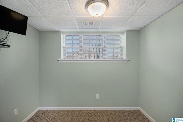 unfurnished room featuring a drop ceiling