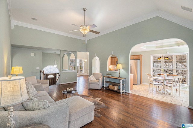 living room with hardwood / wood-style floors, ceiling fan with notable chandelier, and ornamental molding