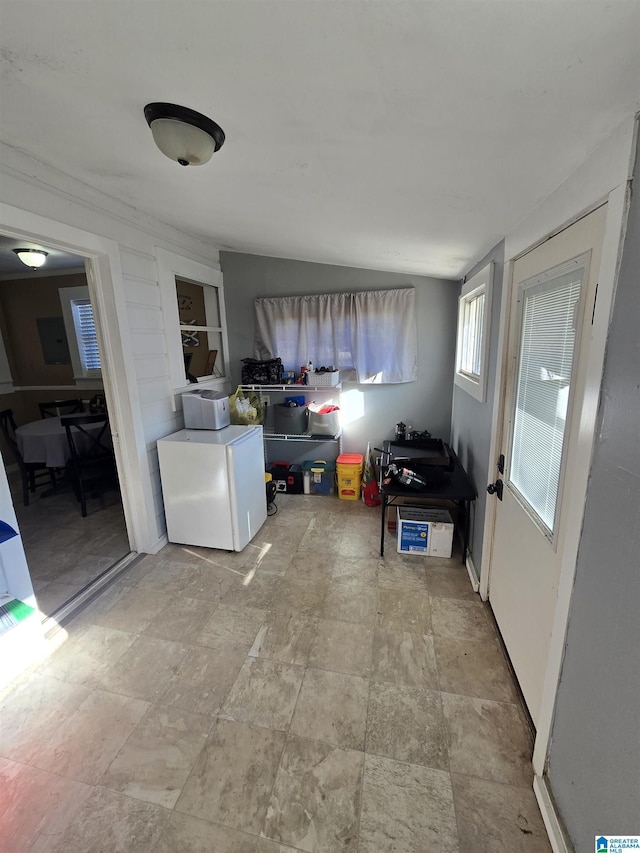 interior space featuring lofted ceiling and refrigerator