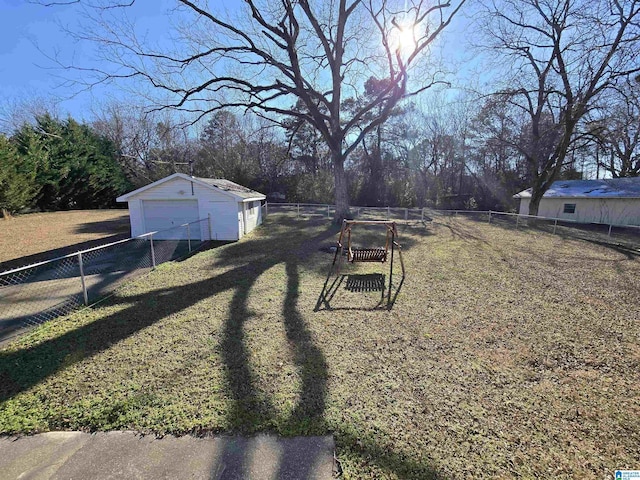 view of yard with a garage and an outbuilding