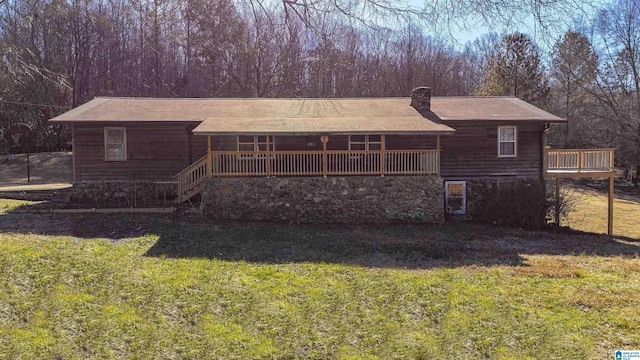 back of property featuring a wooden deck and a yard