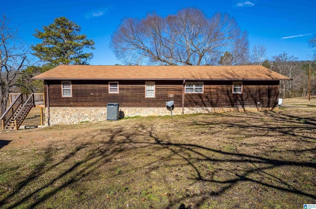 view of side of property featuring central AC and a lawn