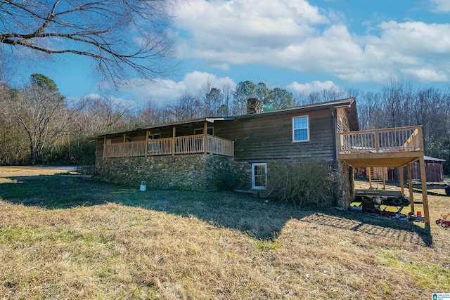 back of house featuring a lawn and a deck