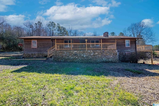 rear view of house featuring a deck and a lawn