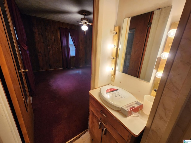 bathroom with vanity, wooden walls, and ceiling fan